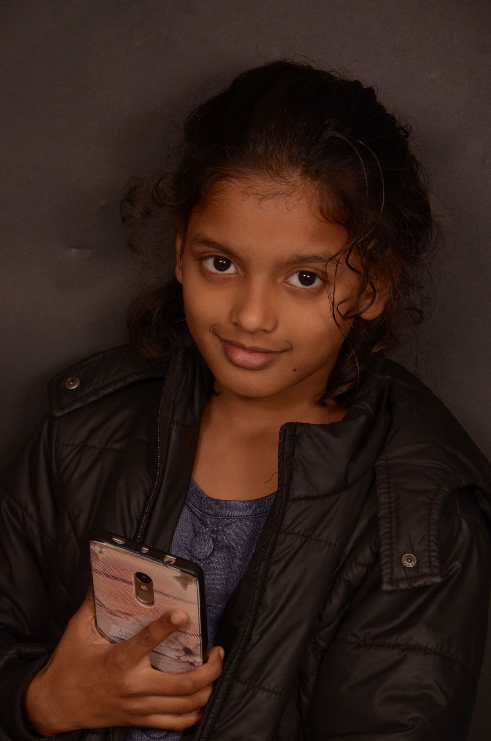 A student smiling while using her phone